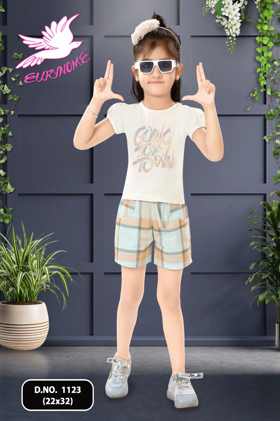 Eurynome Kidswear Girls—Going To Town and taking charge! Bold check shorts and a vibrant sticker top prove outdoor play is for girls who lead, laugh, and play as hard as anyone. Ages 3–9.