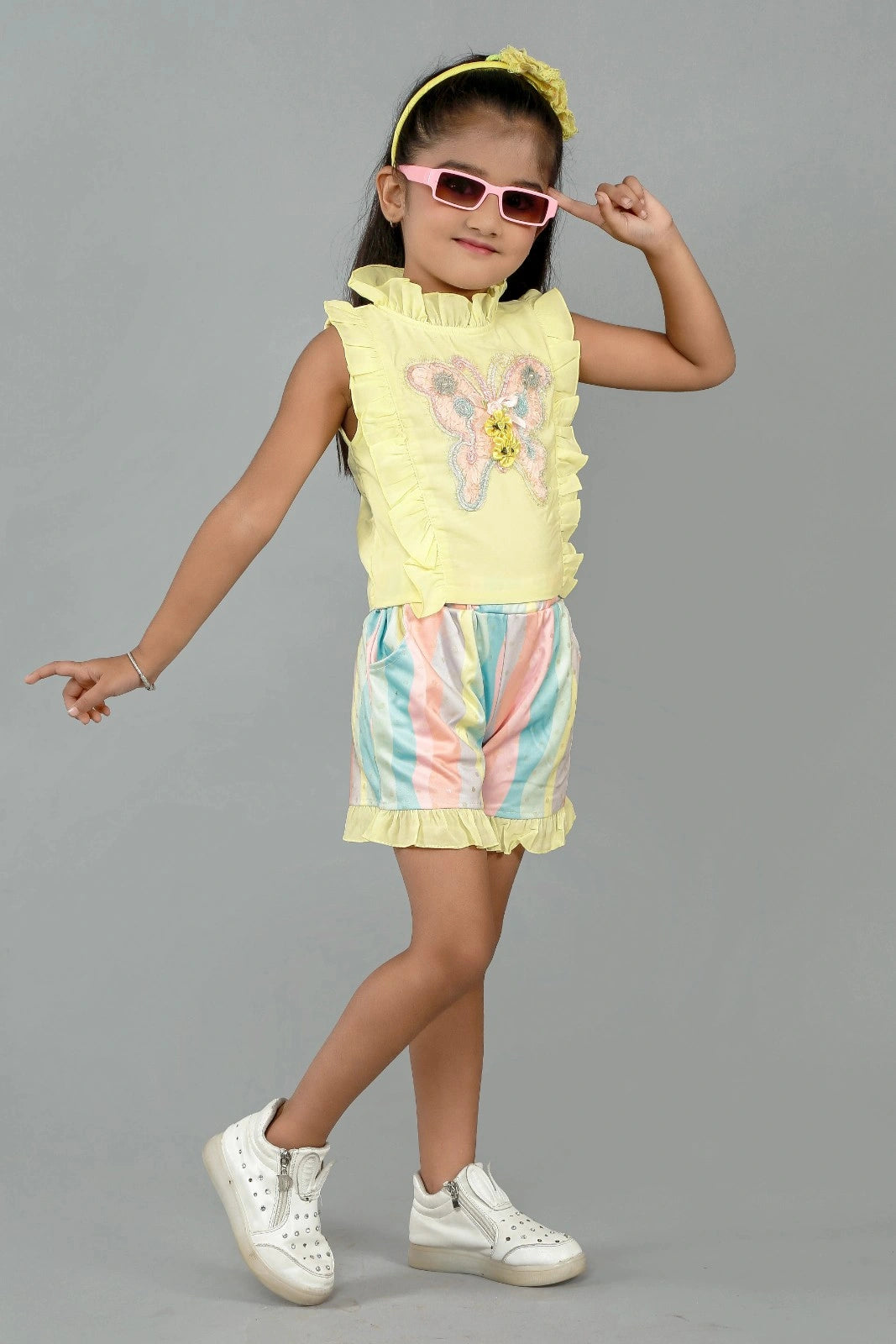 Eurynome Kidswear Girls – Ruffle top & pastel short set, butterfly appliqué, foil wave shorts, comfy chic for ages 3-9.